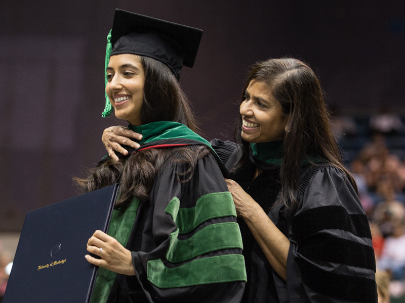 Divya Shenoy is hooded by her mother, Dr. Veena Shenoy, associate professor of pathology.