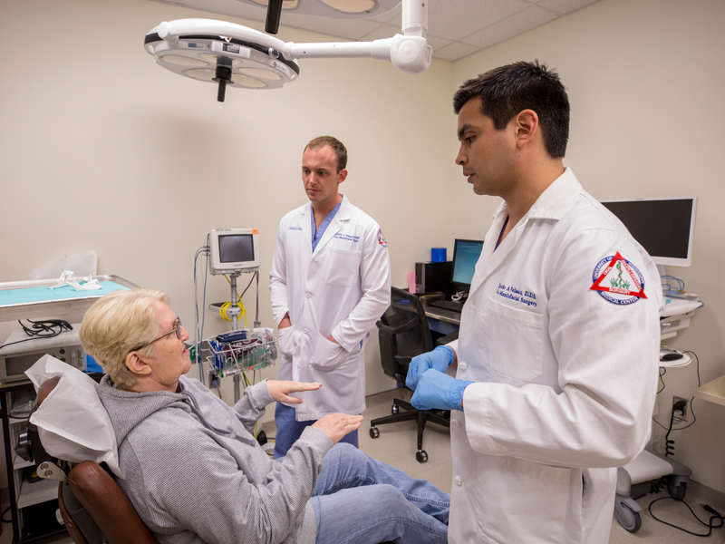 Browning discusses her recovery with Velasco, right, and Dr. Matthew Nimmich, a resident in oral and maxillofacial surgery and pathology.