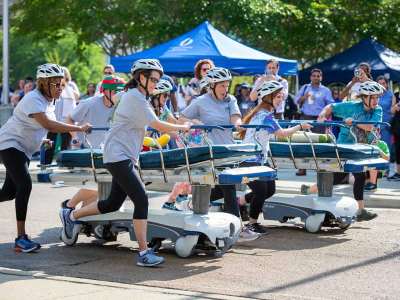 Heavy Breathers from Respiratory in gray, left to right, Levie Beamon, Chris McCoy, Rebecca Cameron and Sherron Carter, racing Kidney Stoners from 2 South.  Visible Kidney Stoners are, front to back, Katie Blackwell, Azure Hayes and Engaray Porter.