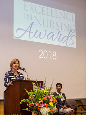 Dr. LouAnn Woodward, vice chancellor for health affairs and dean of the School of Medicine, speaks during the annual Excellence in Nursing Awards. Looking on is Dr. Tonya Moore, administrator of community health services for UMMC's Center for Telehealth.