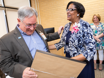 Dr. Ralph Didlake, associate dean for academic affairs, presents Triplett with a citation from UMMC for her years of service.