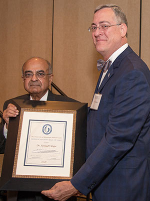 Dr. Seshadri Raju, left, accepts his Hall of Fame award from Dr. Tim Folse, outgoing Medical Alumni Chapter president.
