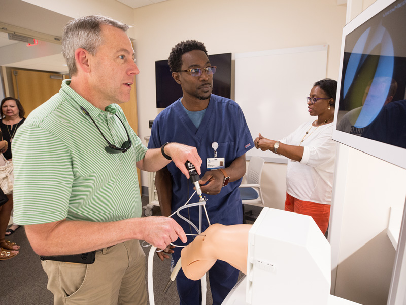 Wade Butler of Brandon, left, tries his luck with one of the orthopedic simulators with the assistance of Patrick Parker, simulation coordinator.