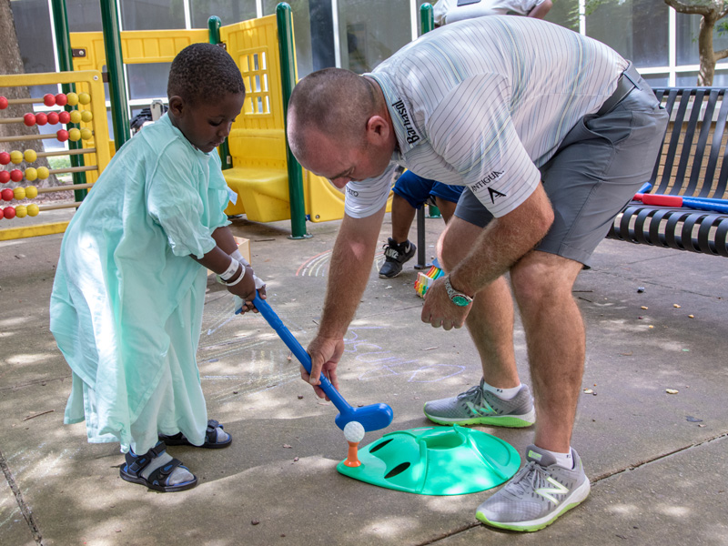 Batson Children's Hospital patient King Lacey of Jackson tees up in a golf lesson from 2017 Sanderson Farms Championship winner Ryan Armour.