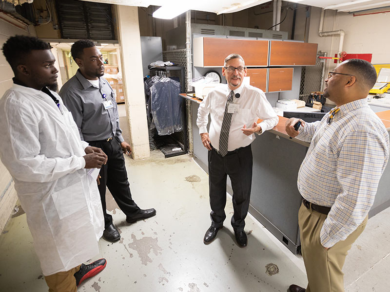 Henry Cote, center, assistant manager for materials distribution, speaks with, left to right, Damerius Shay, Kelvin Williams and Ricardo Thomas.