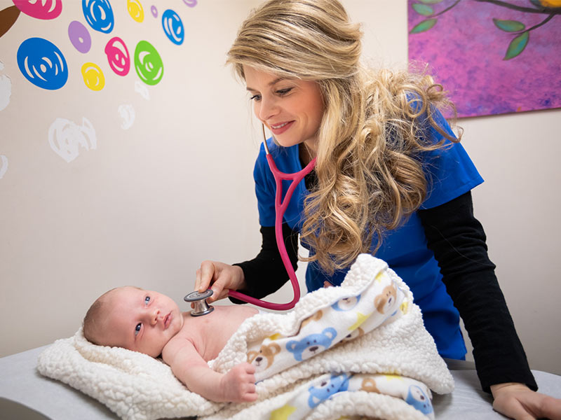 Dr. Amber Googe, UMMC Grenada pediatrician, examines newborn Kane Parker of Winona. Kane's mother, Caitlin Parker, sought help for Kane's feeding issues.