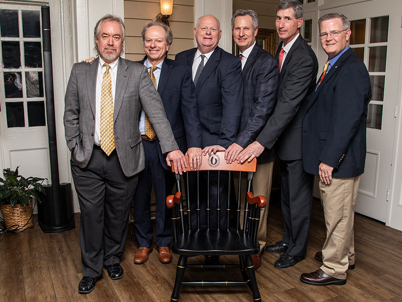 Group photo of Scarbrough and his classmates posed around chair.