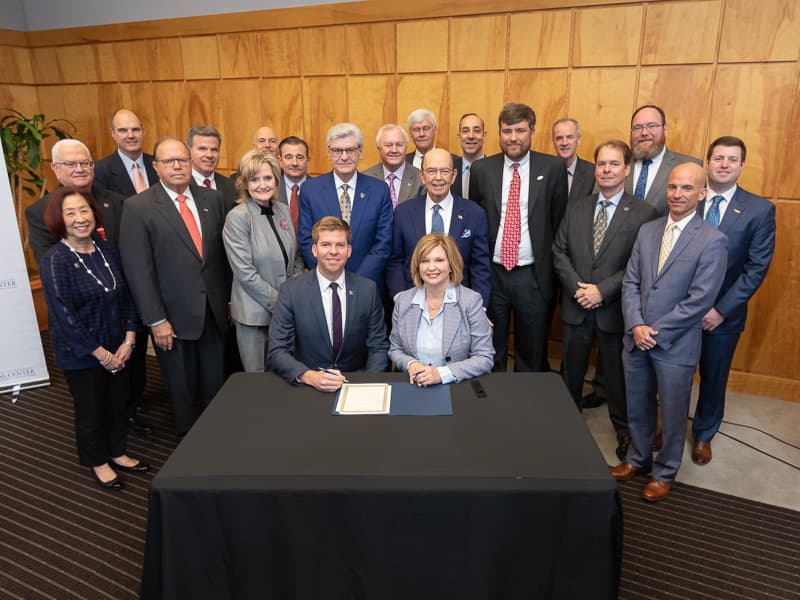Flanked by board members of the FirstNet Authority and officials with UMMC's Mississippi Center for Emergency Services, Ed Parkinson, acting CEO of the FirstNet Authority, and Dr. LouAnn Woodward, vice chancellor for health affairs and School of Medicine dean, sign a memorandum of understanding between FirstNet and UMMC.