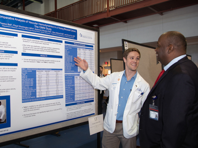 Preston Bell, a third-year medical student, discusses his project with mentor Dr. Ervin Fox, professor of medicine, at the annual Department of Medicine Research Day.