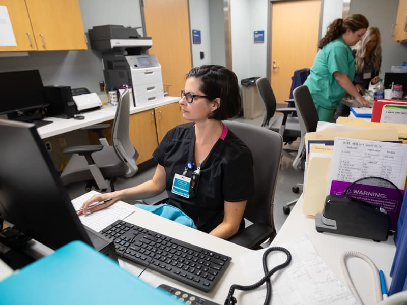 Registered Nurse Cynthia Grice, left, works the desk on 2 West.