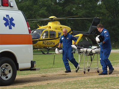 Brock Whitson and David Webb wheel gurney to ambulance.