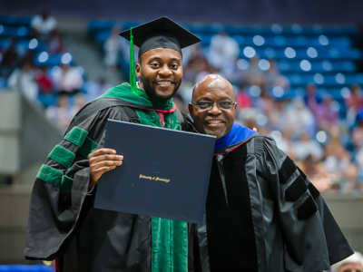 School of Medicine graduate Dr. Sosa Adah received his hood from his father, Dr. Felix Adah, professor of physical therapy in the School of Health Related Professions.