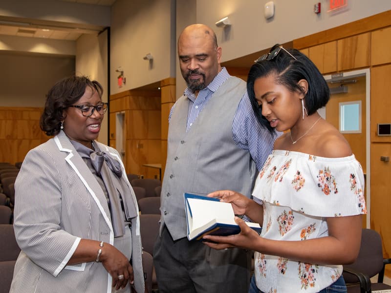 Among those attending Dr. Loretta Jackson-Williams' address in the Student Union are her husband James Williams and their daughter Taylor, who's thumbing through a copy of Randy Pausch's "The Last Lecture."