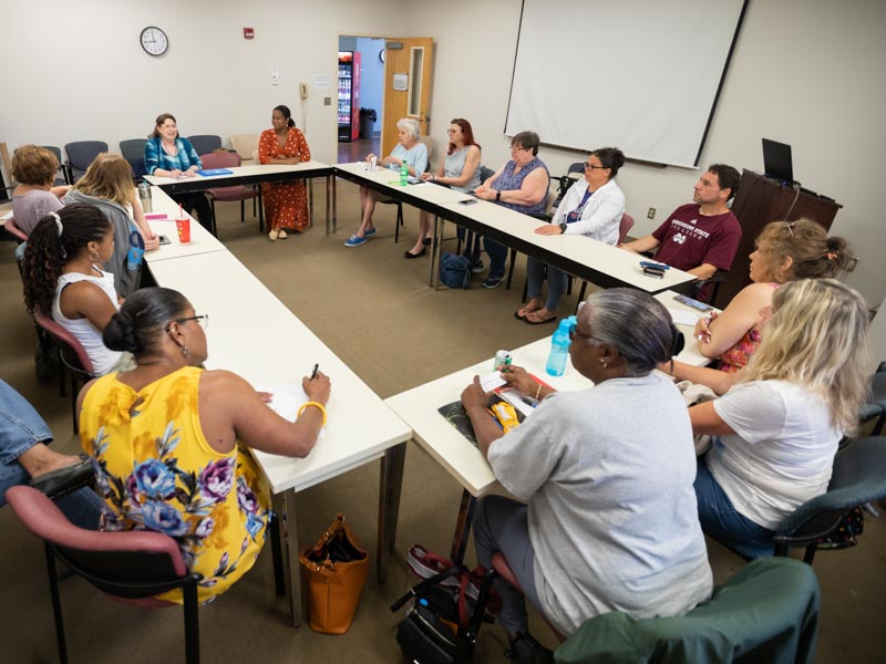 Back left, Sue Ann Meng, leads the support group with Dr. Liana Singh, geriatrics fellow, back right.