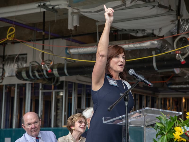 Pediatrics chair Dr. Mary Taylor signals for the beam to rise to the top of the pediatric expansion.