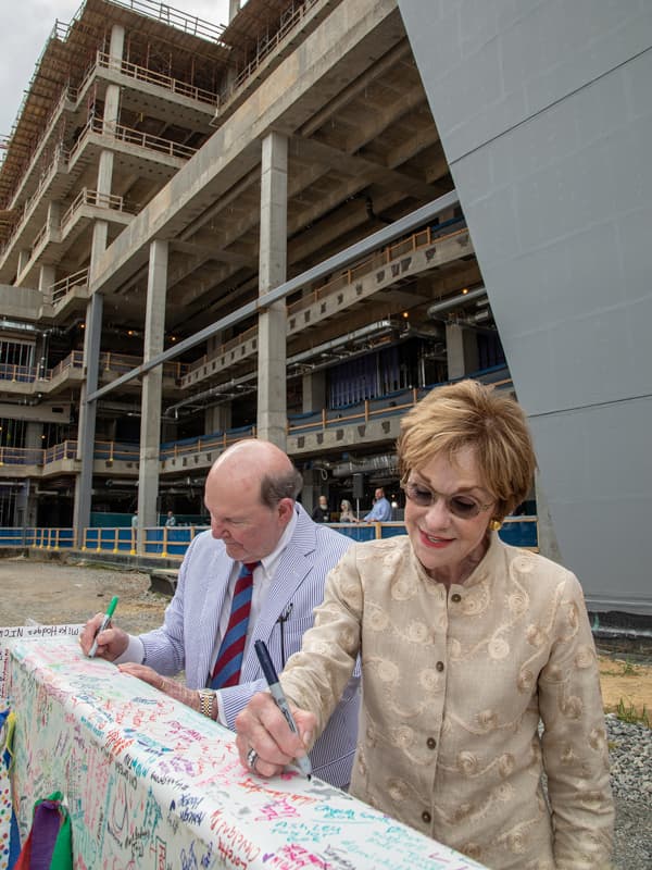 Campaign for Children's of Mississippi chairs Joe and Kathy Sanderson sign the beam before the topping-out ceremony for UMMC's pediatric expansion.