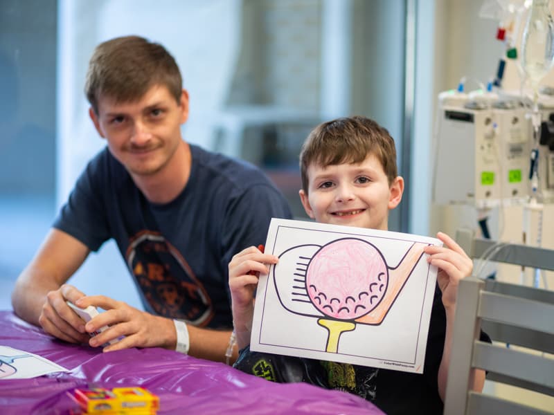 Children's of Mississippi patient Braylon Jordan of Pelahatchie shows his coloring skills as dad Jonathan looks on.