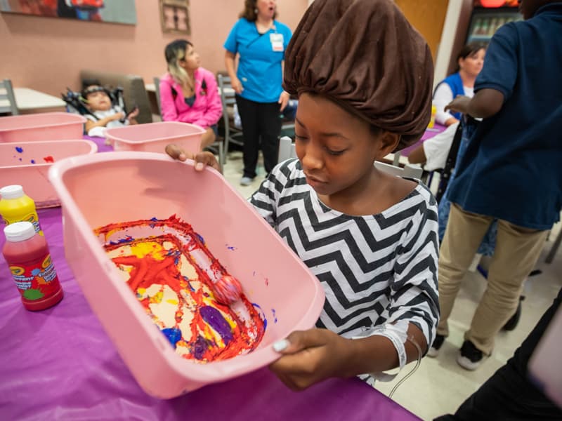 Mylaijah Simmons of Laurel, a Children's of Mississippi patient, creates art by rolling a golf ball across paint.