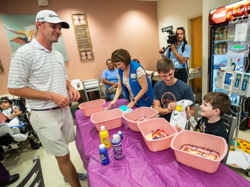 Sanderson Farms Championship golfer Wes Roach visits with Children's of Mississippi patient Braylon Jordan of Pelahatchie and his dad, Jonathan.