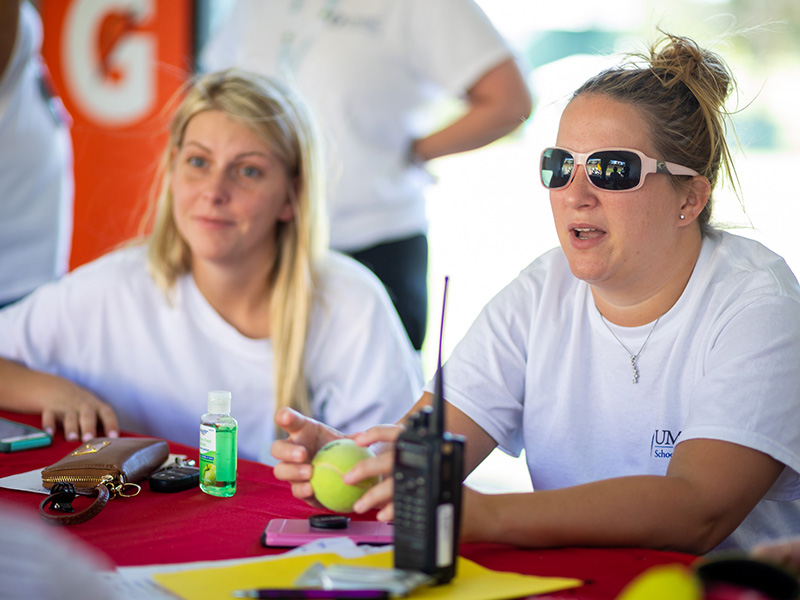 Ashley Breeland, right, a student in the masters of health care administration program, shares about volunteering at the first aid tent as Chelsea Pickle, left, of the RN to BSN program, listens.