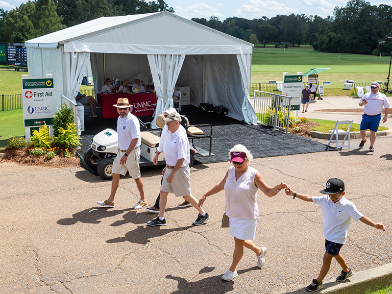 Tournament attendees pass by the first aid tent manned by the University of Mississippi School of Nursing.