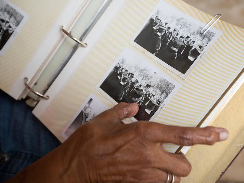 Sifting through one of her scrapbooks, Dr. Helen Barnes finds photos from her 1958 Howard University graduation day ceremony.