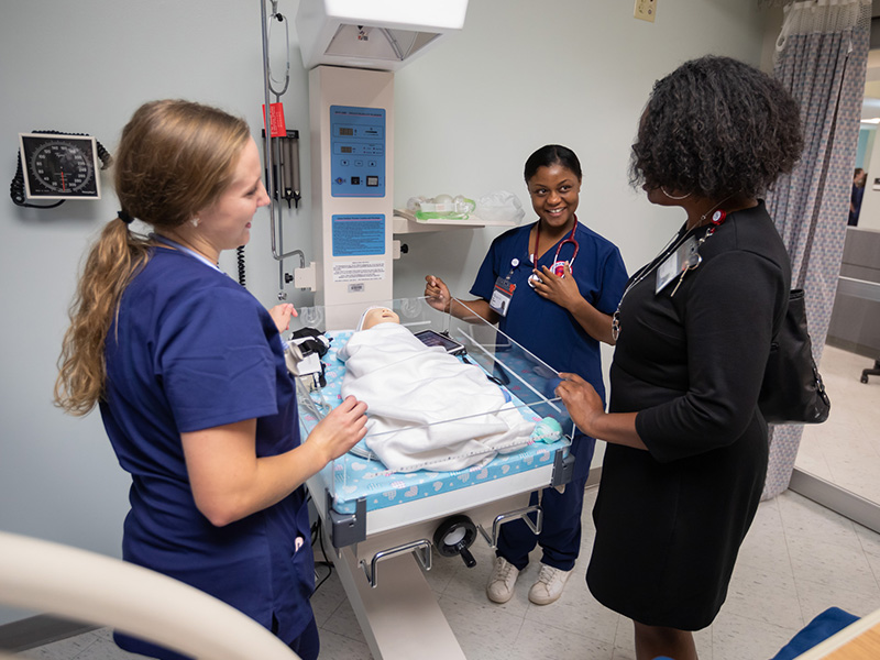 Students Lauren Frazier, left, and Iesha Richardson speak with SON Education Administrator Tanya Perry as Perry tours the school's new Oxford facility.