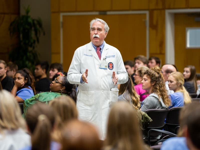 Dr. David Felton, center, professor and dean of the School of Dentistry, addresses students after they listen to author Lauren.