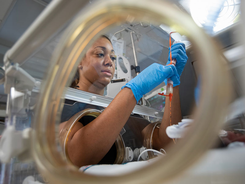 Javita Fitzgerald, an RN in Children's of Mississippi's neonatal intensive care unit, prepares breast milk to be fed to a patient via feeding tube.