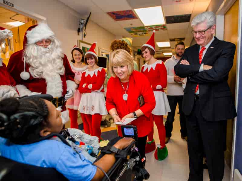 Gov. Phil Bryant, right, and First Lady Deborah Bryant, center, along with Santa, Mrs. Claus and a team of elves, visit with Children's of Mississippi patient DeAsia Scott.