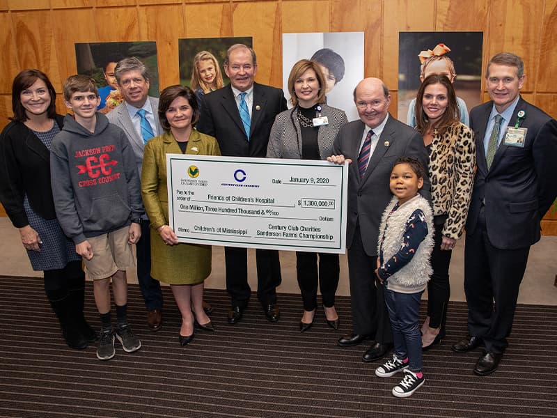 Celebrating the record-breaking Century Club Charities donation to Friends of Children's Hospital are, from left, Dr. Mary Taylor, Suzan B. Thames Chair, professor and chair of Pediatrics; Children's of Mississippi patient Felton Walker; Sanderson Farms Championship Executive Director Steve Jent; Friends of Children's Hospital Board Chair Melanie Morgan; Century Club Charities President Pat Busby; Dr. LouAnn Woodward, vice chancellor for health affairs and dean of the School of Medicine; Sanderson Farms CEO and Chairman of the Board Joe Sanderson; Children's of Mississippi patient Tiana Rollins; Sanderson Farms Director of Marketing Hillary Burroughs; and Children's of Mississippi CEO Guy Giesecke.