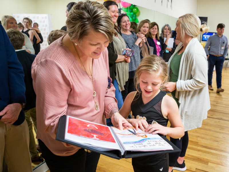 Sybil and her mom, Tara, look over well-wishes and drawings from her friends and fellow dancers.