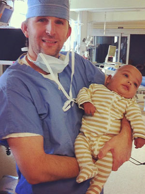 Hal Hammett, a certified registered nurse anesthetist, holds Cohran's xx-month-old son Deuce Bloodsaw after his long stay in the Neonatal Intensive Care Unit.