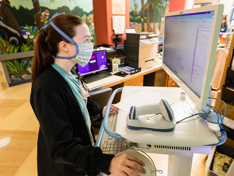 Registered Nurse Amber Williams reviews patient information in the Children's Cancer Clinic.