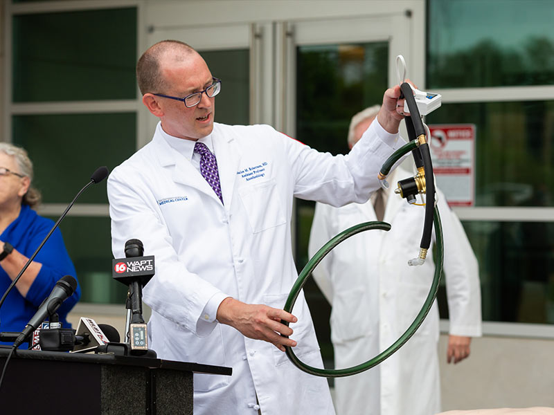 Dr. Charles Robertson, assistant professor of anesthesiology, holds up a ventilator built from garden hose and other readily available parts. The ventilators are meant for use only if UMMC exhausts other ventilator options.