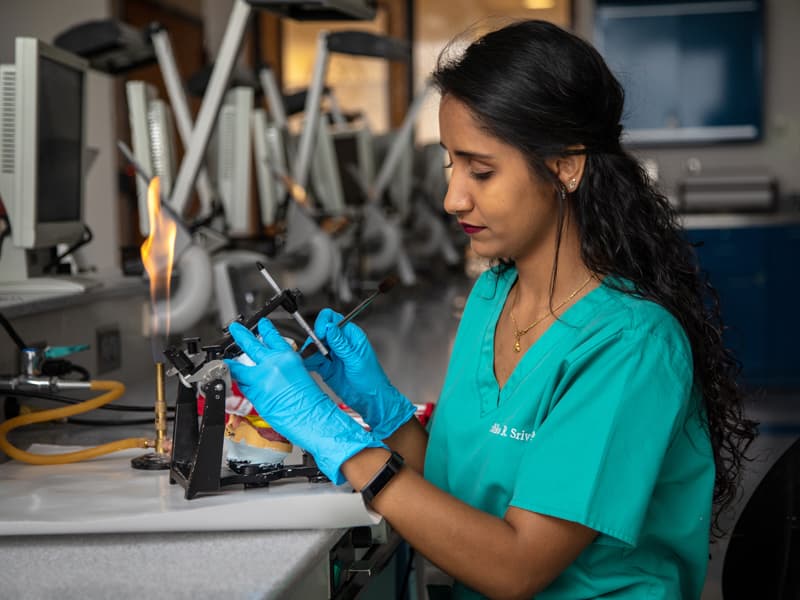 Ambika Srivastava waxes a pair of dentures in the bench lab.