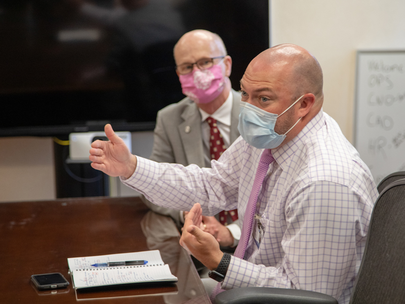 As Dr. Charles O'Mara looks on, Jason Zimmerman, right, associate chief nursing officer for adult nursing services, speaks during the UMMC Health System weekly leadership meeting to discuss COVID-19 response.