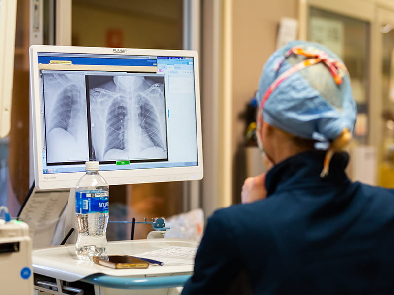 Dr. Jessie Harvey closely examines a COVID-19 patient's lung scans to track progression and severity of the disease.