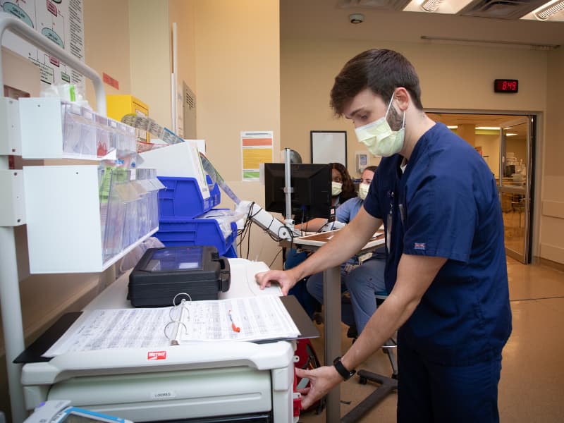 Christian opens the code cart to see if any supplies need to be restocked and if they are in the proper place.