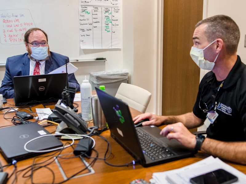 Among UMMC officials who plan for a double-whammy disaster are Dr. Jonathan Wilson, left, chief administrative officer and COVID-19 incident manager, and Jason Smith, manager of emergency services, meeting here in the incident command center.