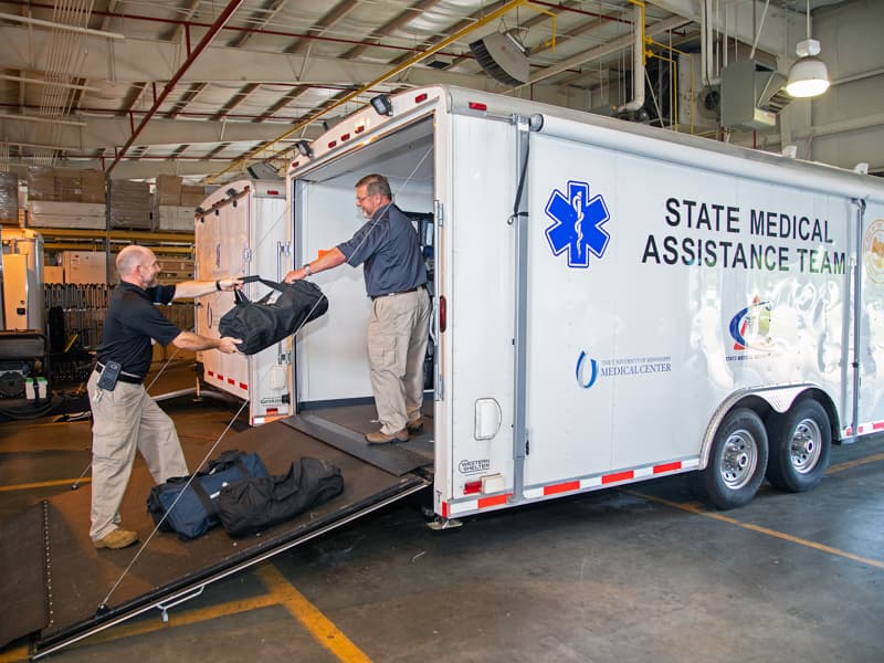 Heath Williams, left, NRP, Emergency Response Magager, Terry McLeod, Clinical Director, SER-Ctr for Emergency Services, load needed equipment into a trailer in case the Emergency Response teams are needed.