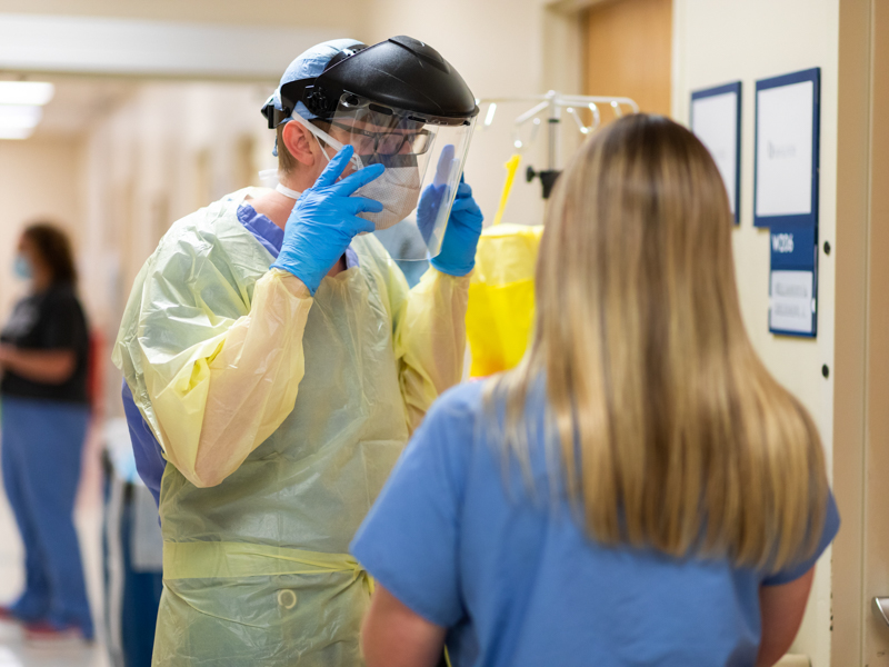 OB-GYN resident Dr. Josh Blaylock prepares to enter the room of a COVID-19 patient on the Labor and Delivery floor.