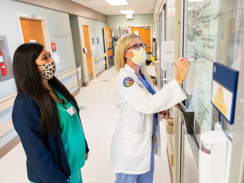 Jocelyn Rollins, left, and Channelle Hunter, advanced practice nurse practitioners, round to patient rooms in the CVICU.