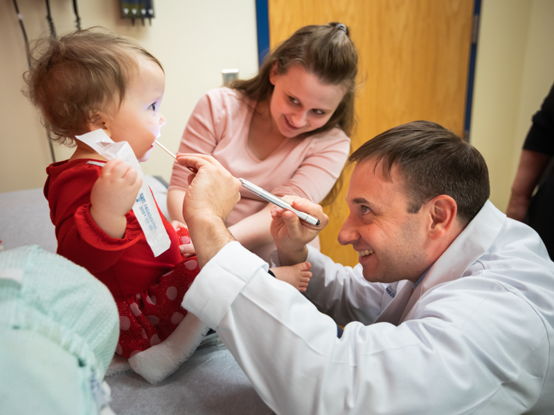 Dr. Ian Hoppe takes a look at Anna Claire Carlisle post surgery as her mom, Ariel Davidson, looks on.