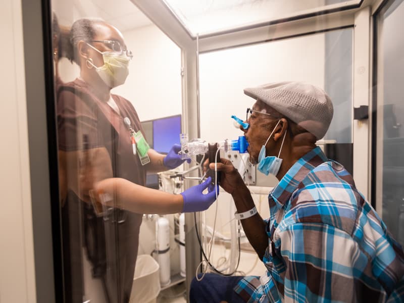 Pulmonary respiratory therapist Kimberly Lockett helps patient Sammie Bass get started on a lung function test to gauge how well he can breathe.