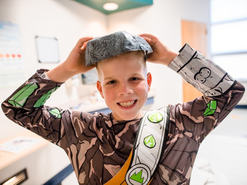 Children's of Mississippi patient Hayes Jenkins of Clinton smiles while awaiting reverse trick-or-treating to arrive at his room.