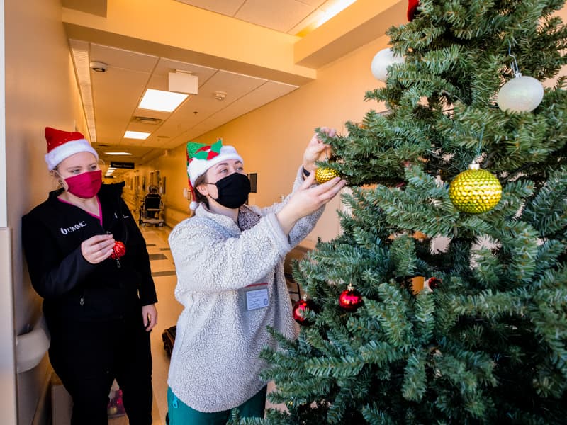 First year medical students Taylor Cupit, left, and Cambria Boone decorate a Christmas tree on 4 South