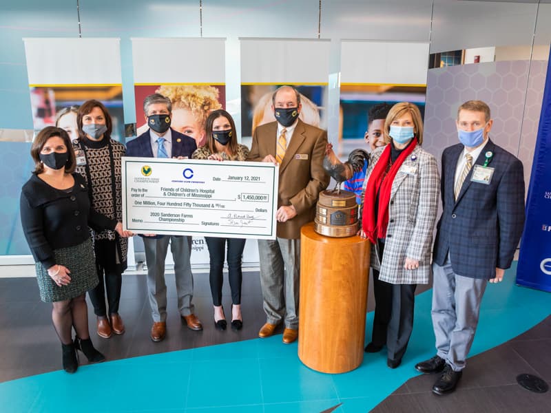 Celebrating a record-breaking $1.45 million donation from the Sanderson Farms Championship to benefit Children's of Mississippi are, from left, Friends of Children's Hospital board chair Melanie Morgan; Dr. Mary Taylor, Suzan B. Thames Chair, professor and chair of Pediatrics at UMMC; Steve Jent, Sanderson Farms Championship executive director; Hilary Burroughs, director of marketing for Sanderson Farms; Pat Busby, Century Club Charities president; Dr. LouAnn Woodward, vice chancellor for health affairs and dean of the School of Medicine; and Children's of Mississippi CEO Guy Giesecke.