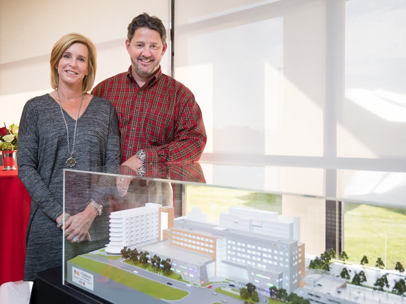 Priscilla and Dave O'Donnell stand beside a model of the Sanderson Tower shortly before its groundbreaking ceremony on Dec. 1, 2017.