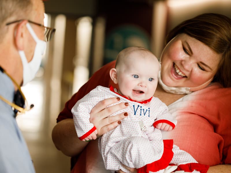 Vivi Hebert and her mom, Crystal, share a laugh with Dr. William Moskowitz, Vivi's cardiologist.